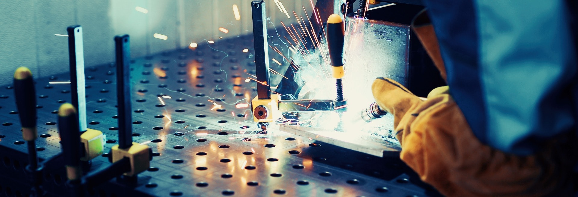 man welds at the factory working in metal industry